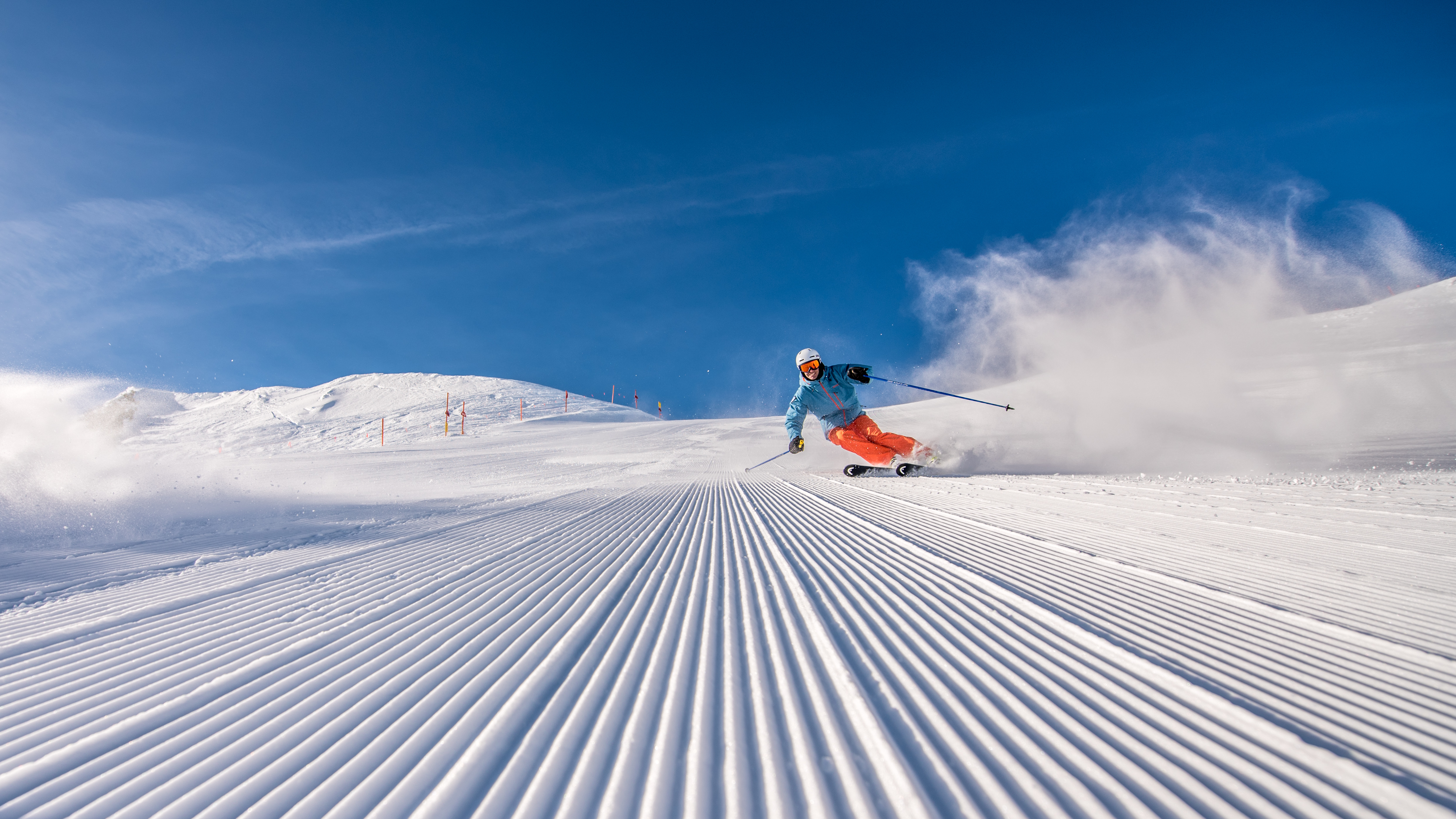 groomer_skiing_bluebird